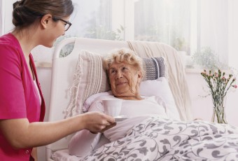 Senior in bed with caregiver