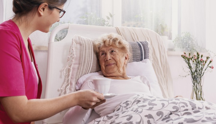 Senior in bed with caregiver